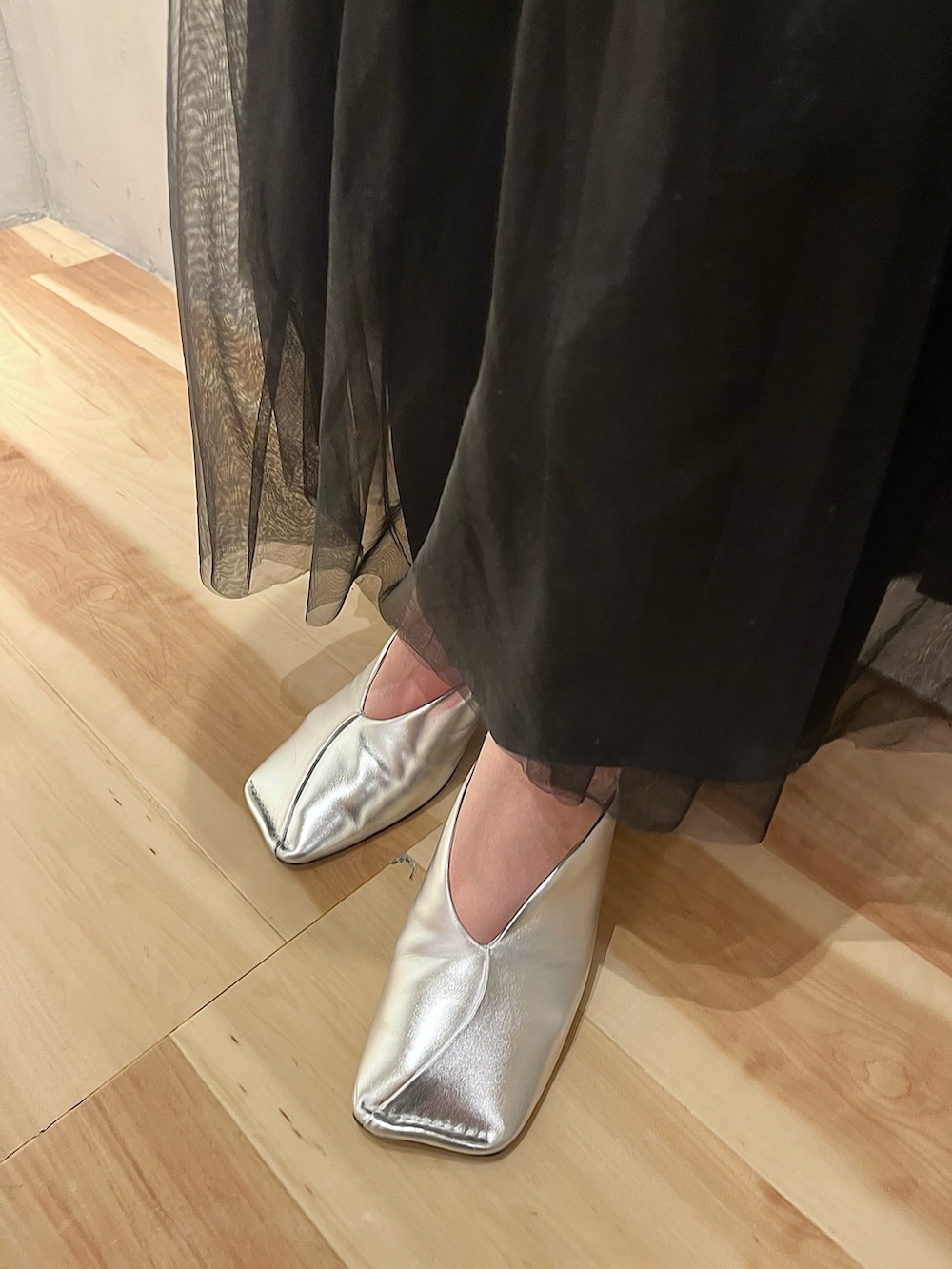 ブラック系のスカート、シルバー系のパンプス、ホワイト系のシャツ/ブラウスを着用したレディースの冬コーディネートの10枚目の写真