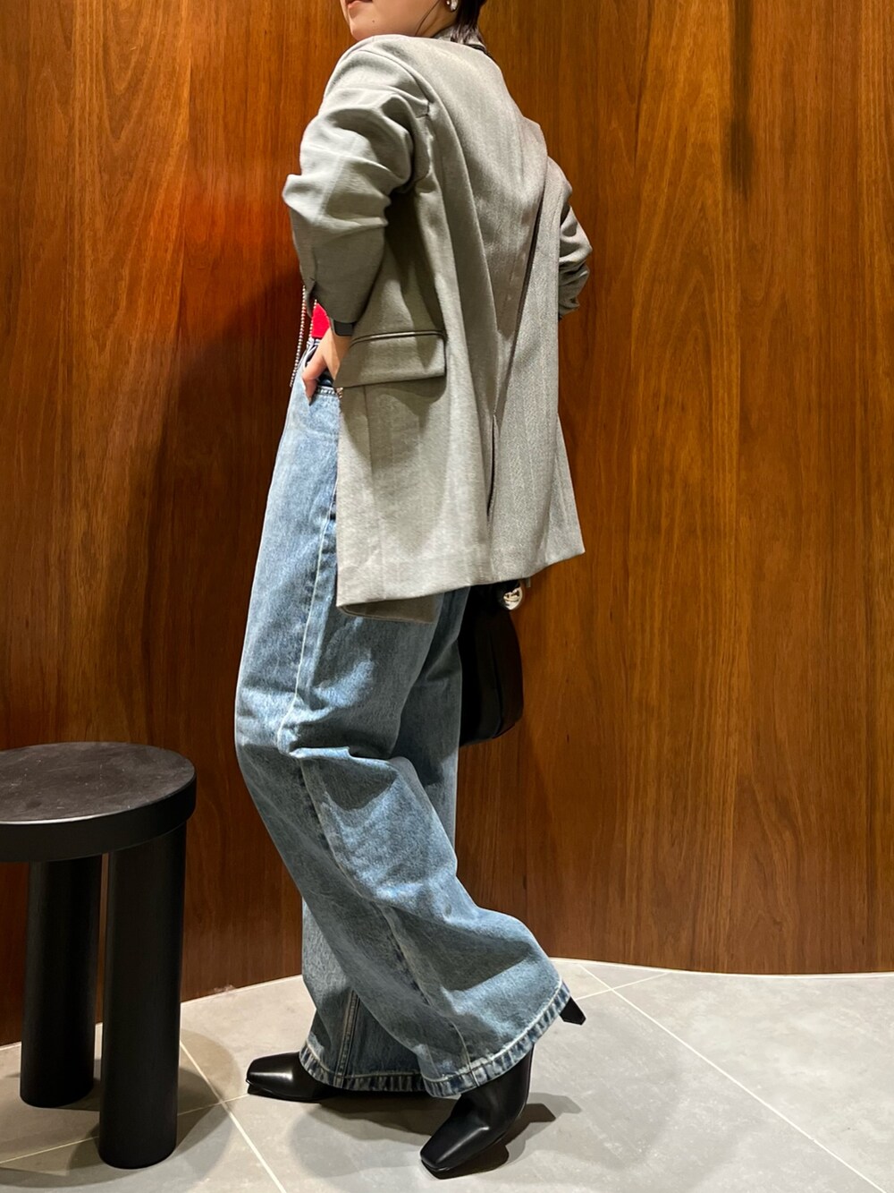 ブラック系のテーラードジャケット、レッド系のカーディガン/ボレロ、ブラック系のハンドバッグを着用したレディースの秋コーディネートの2枚目の写真