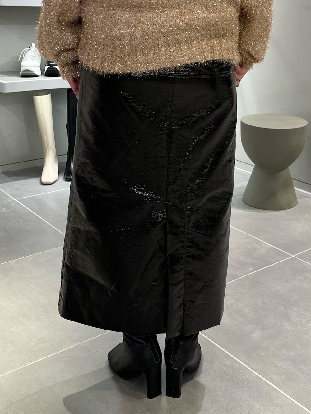 ベージュ系のニット/セーター、ブラック系のブーツ、ブラック系のハンドバッグを着用したレディースの秋コーディネートの8枚目の写真