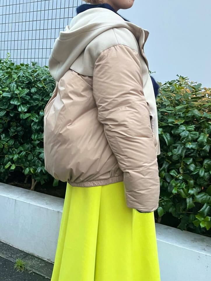 ベージュ系のダウンジャケット/コート、ブルー系のニット/セーター、イエロー系のスカートを着用したレディースの秋コーディネートの5枚目の写真