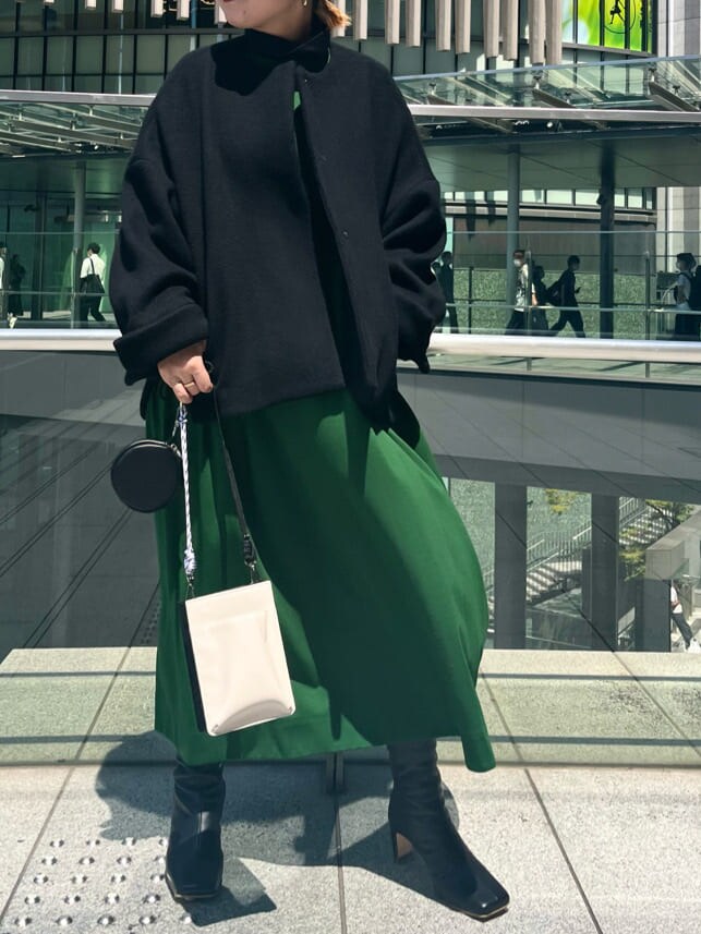 グリーン系のワンピース、ホワイト系のショルダーバッグ、ブラック系のノーカラーコートを着用したレディースの夏コーディネートの2枚目の写真
