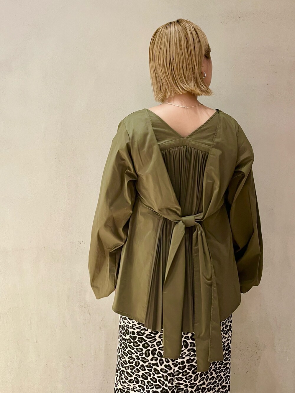 グリーン系のシャツ/ブラウス、ホワイト系のスカート、ブラック系のブーツを着用したレディースの秋コーディネートの5枚目の写真