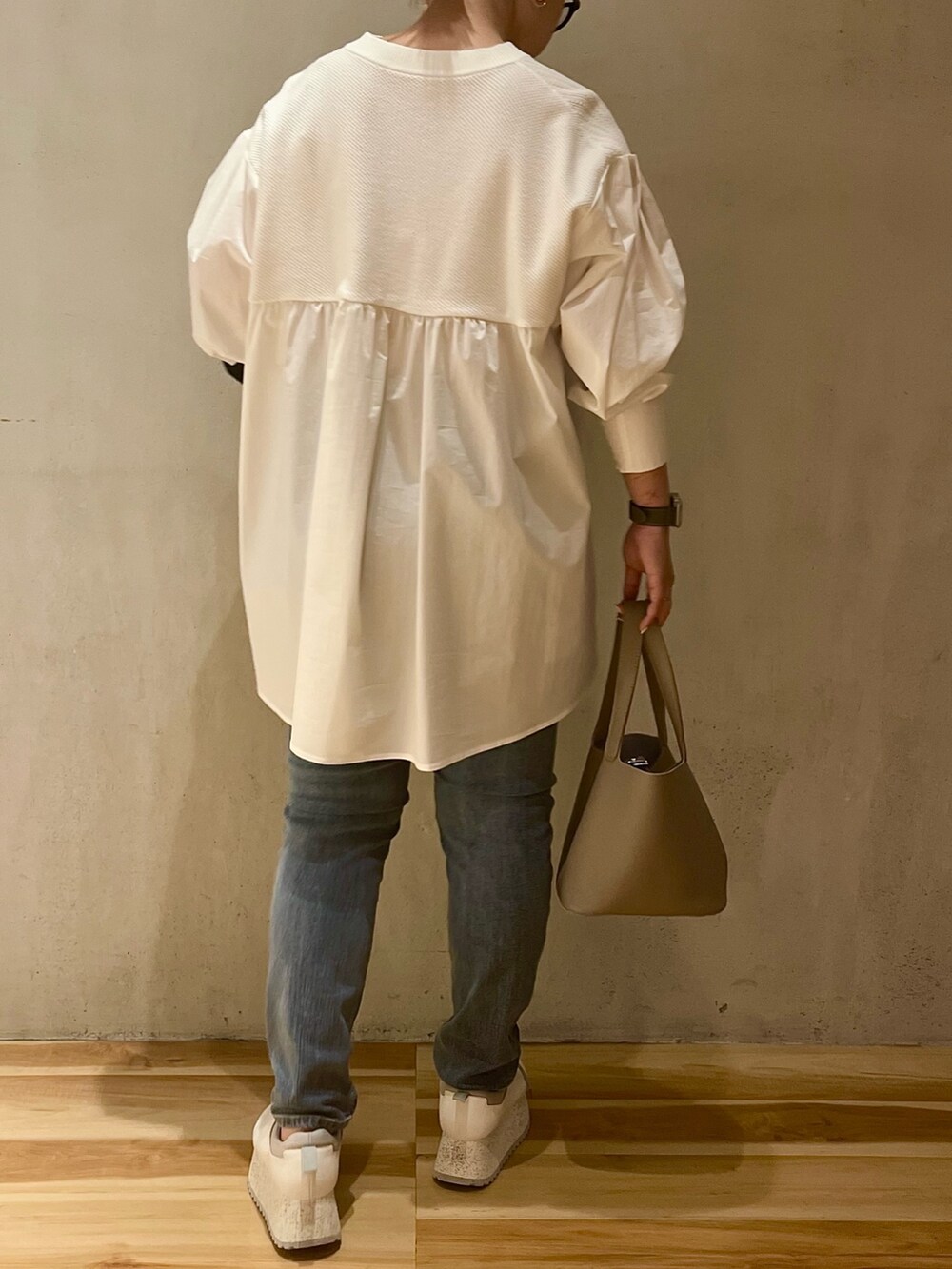 ブラック系のテーラードジャケット、ホワイト系のシャツ/ブラウス、ブルー系のデニムパンツを着用したレディースの冬コーディネートの7枚目の写真