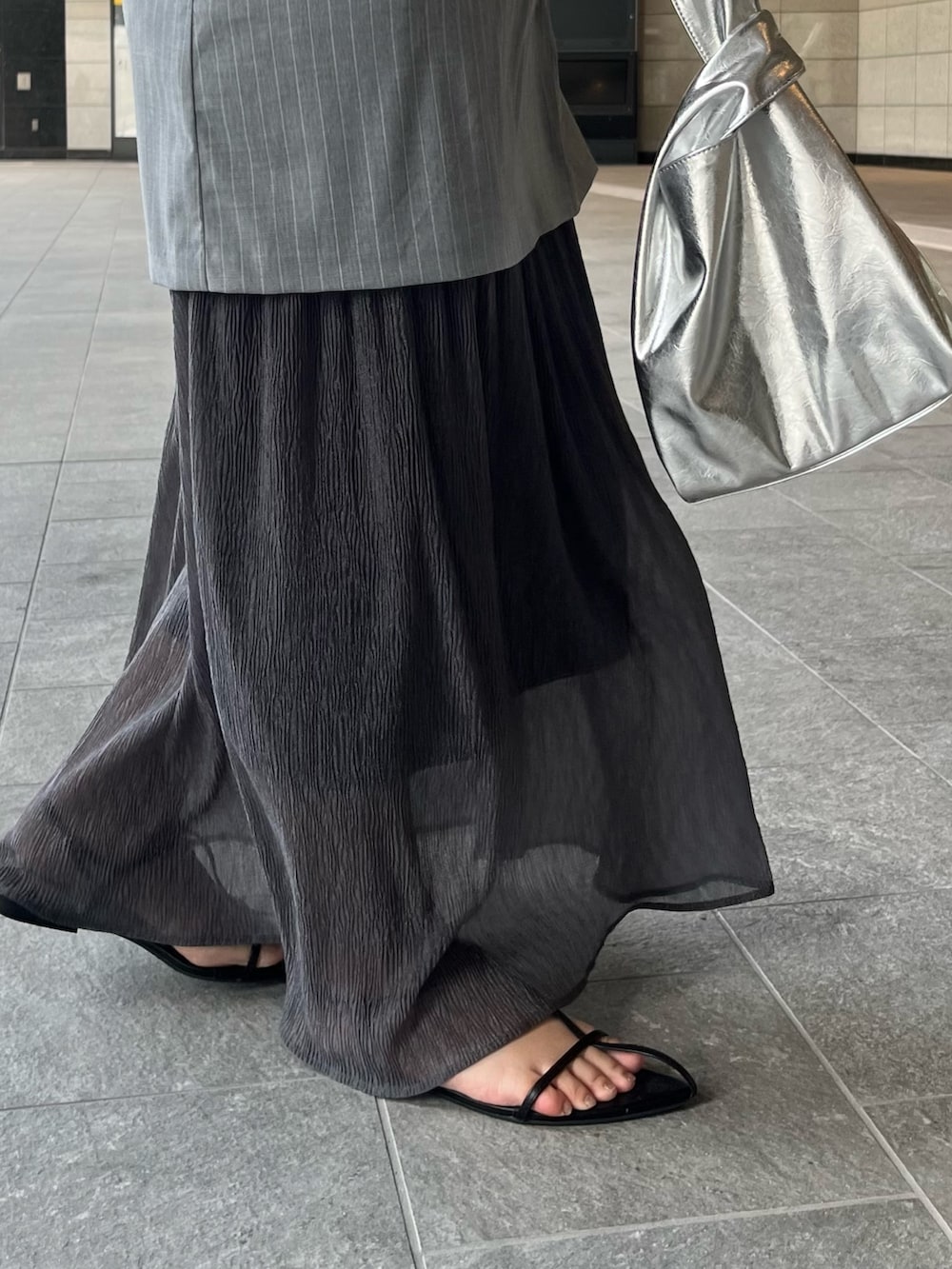 ブラック系のニット/セーター、グレー系のワンピース、シルバー系のハンドバッグを着用したレディースの夏コーディネートの7枚目の写真