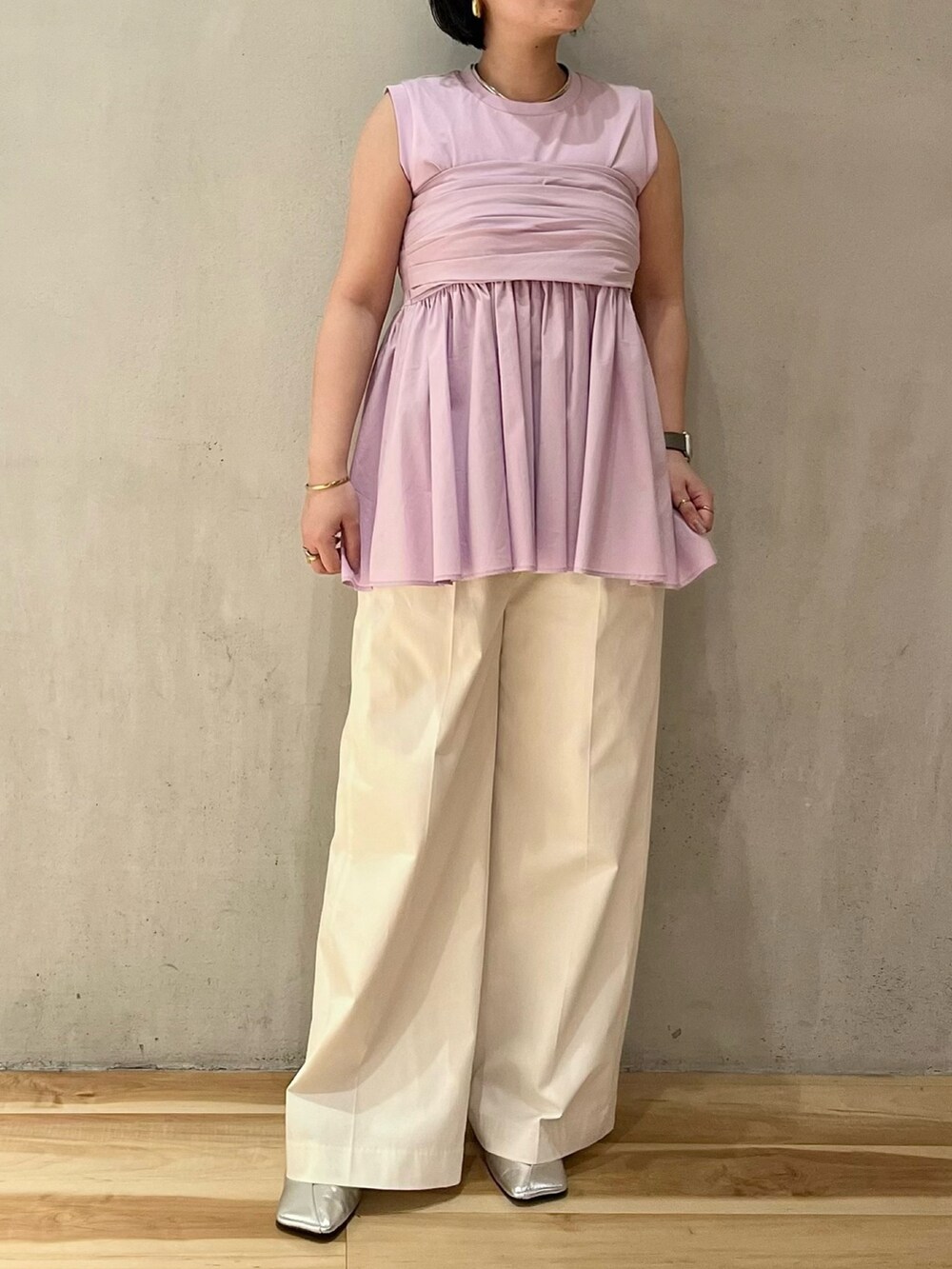 パープル系のタンクトップ、シルバー系のパンプス、ホワイト系のその他パンツを着用したレディースの冬コーディネートの2枚目の写真