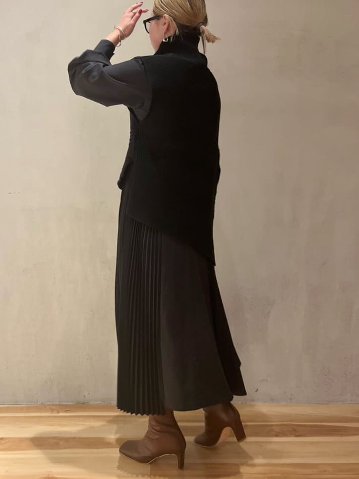 ブラウン系のブーツ、ベージュ系のショルダーバッグ、ブラック系のワンピースを着用したレディースの秋コーディネートの2枚目の写真