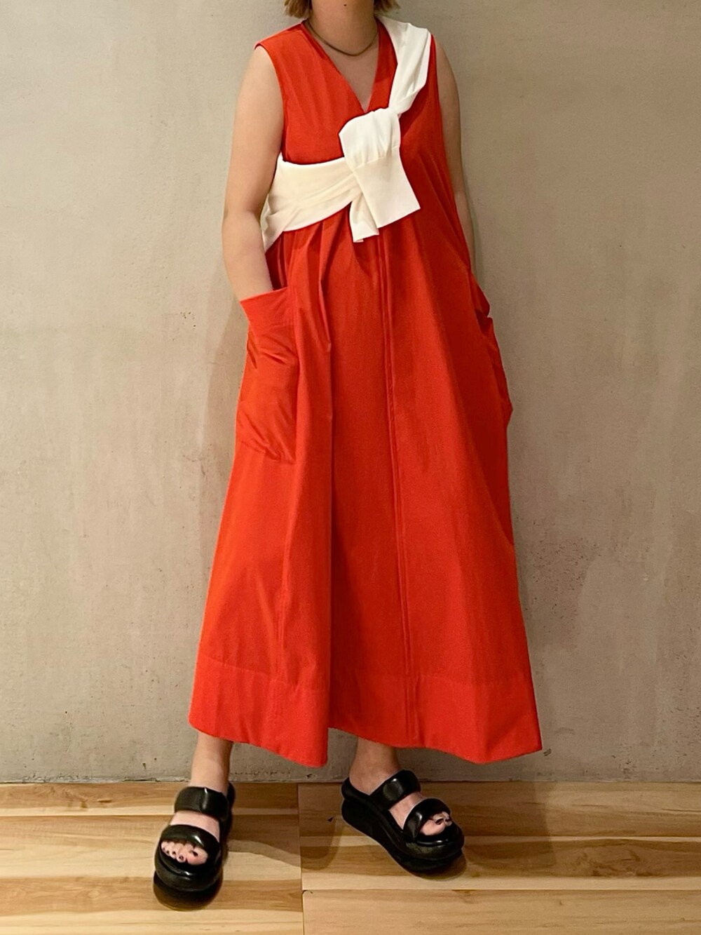 ホワイト系のカーディガン/ボレロ、ブラック系のサンダル、レッド系のワンピースを着用したレディースの夏コーディネートの3枚目の写真