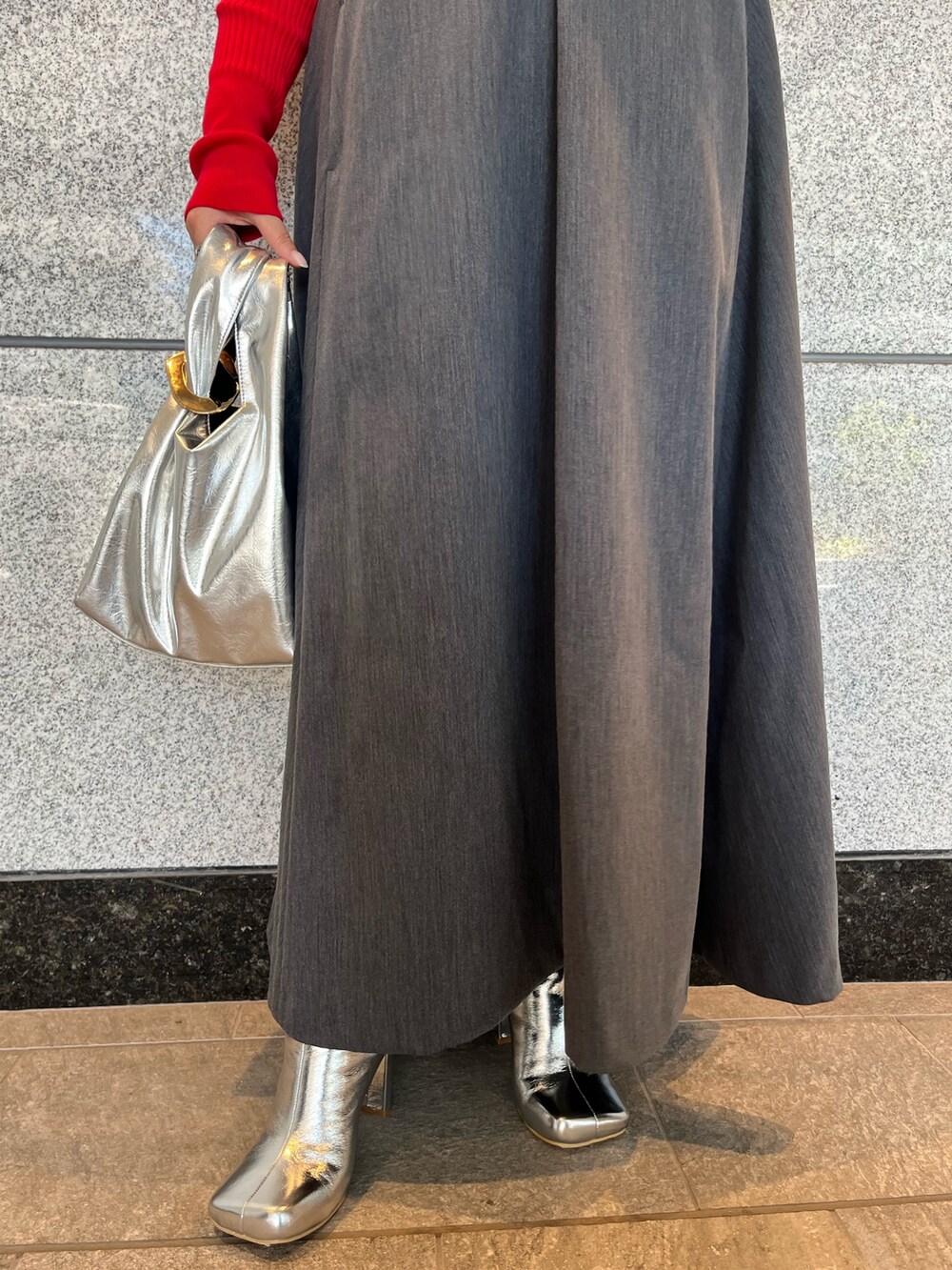 グレー系のジャンパースカート、シルバー系のブーツ、ゴールド系のハンドバッグを着用したレディースの夏コーディネートの9枚目の写真
