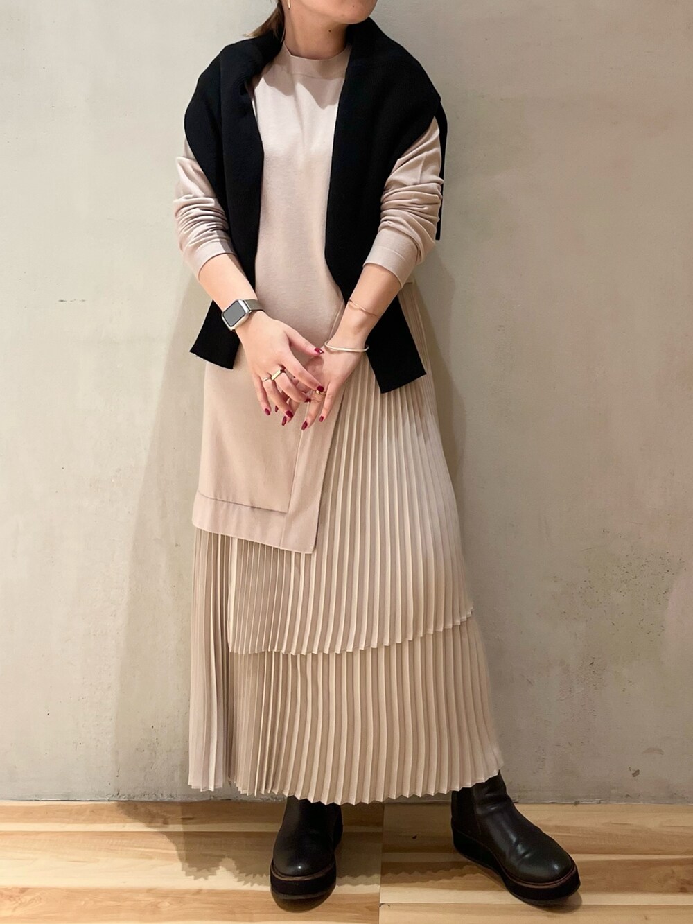 グリーン系のチェスターコート、ブラック系のカーディガン/ボレロ、ベージュ系のワンピースを着用したレディースの冬コーディネートの5枚目の写真