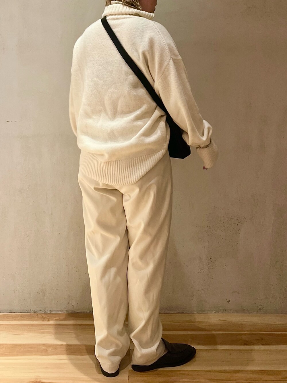 ホワイト系のニット/セーター、ホワイト系のその他パンツ、ブラック系のハンドバッグを着用したレディースの夏コーディネートの3枚目の写真