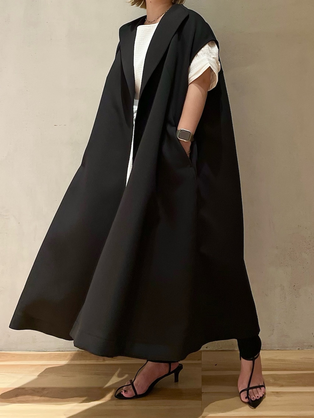 ブラック系のノーカラーコート、ホワイト系のシャツ/ブラウス、ブラック系のスラックスを着用したレディースの夏コーディネートの2枚目の写真