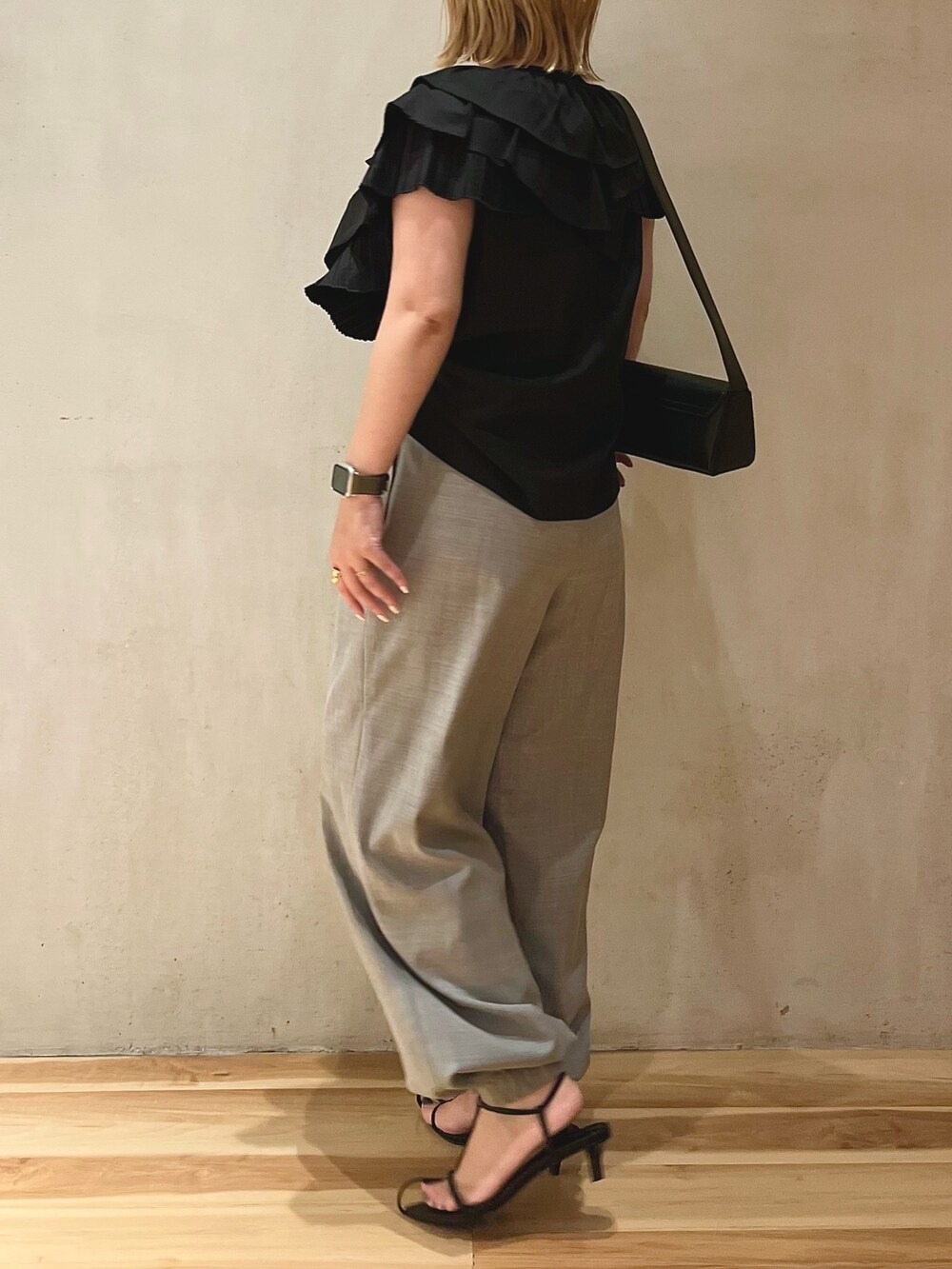 ブラック系のシャツ/ブラウス、グレー系のスラックス、ブラック系のショルダーバッグを着用したレディースの夏コーディネートの2枚目の写真