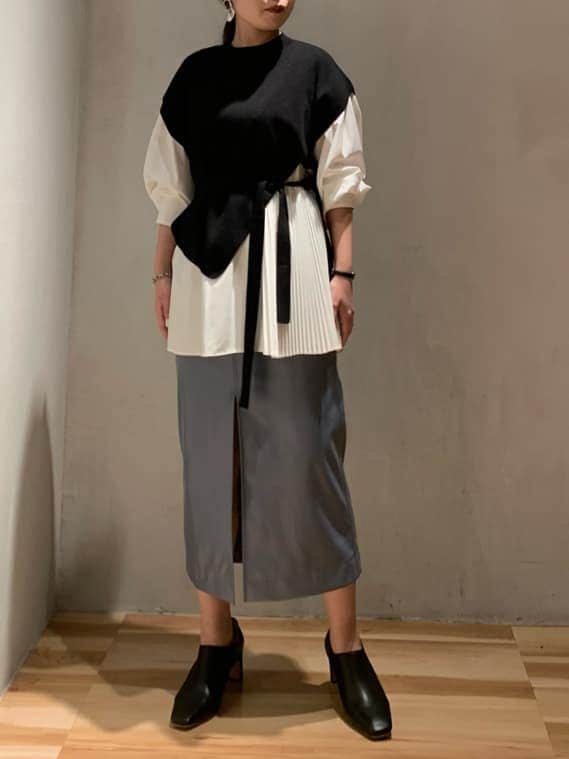 ブラック系のブーツ、ブラック系のニット/セーター、ブルー系のスカートを着用したレディースの秋コーディネートの3枚目の写真