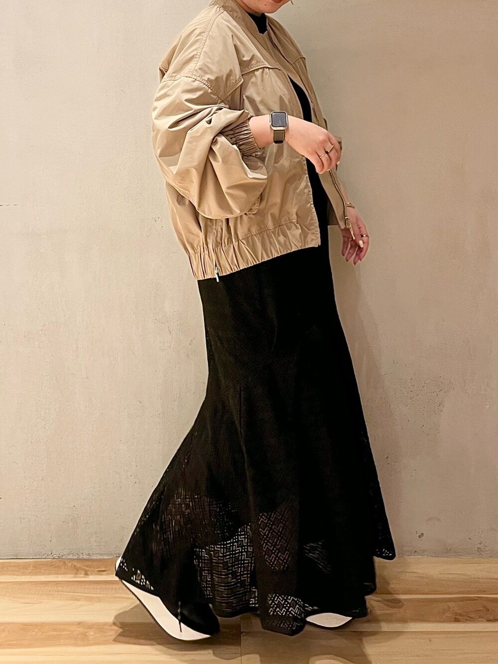 ベージュ系のブルゾン、ブラック系のスニーカー、ブラック系のワンピースを着用したレディースの春コーディネートの2枚目の写真