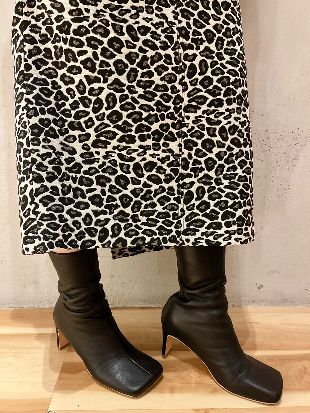 ブラック系のTシャツ/カットソー、ホワイト系のスカート、ブラック系のブーツを着用したレディースの春コーディネートの10枚目の写真