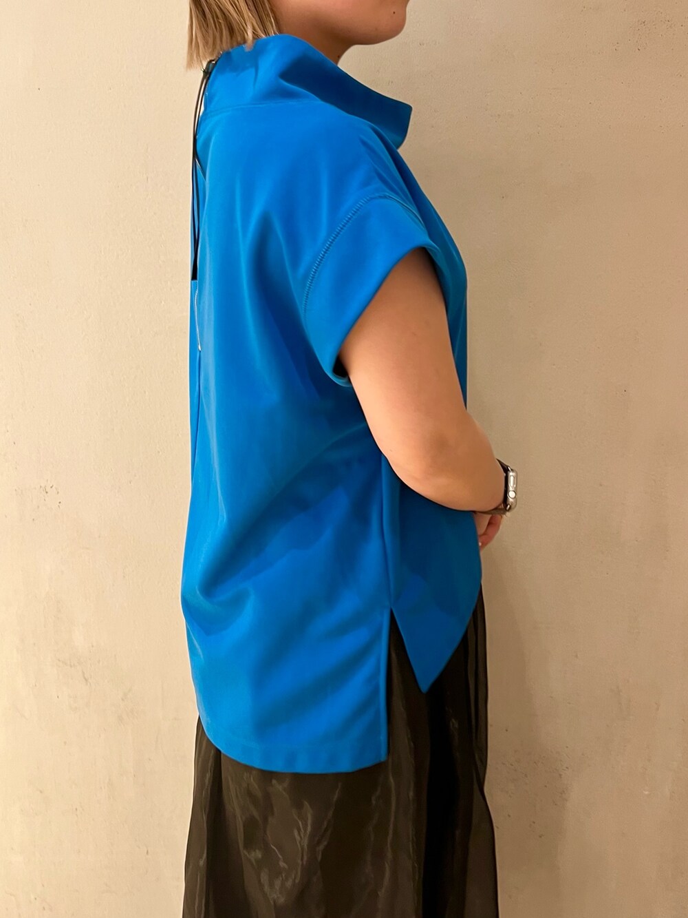 ブルー系のTシャツ/カットソー、ブラック系のスカート、ブラック系のサンダルを着用したレディースの冬コーディネートの6枚目の写真