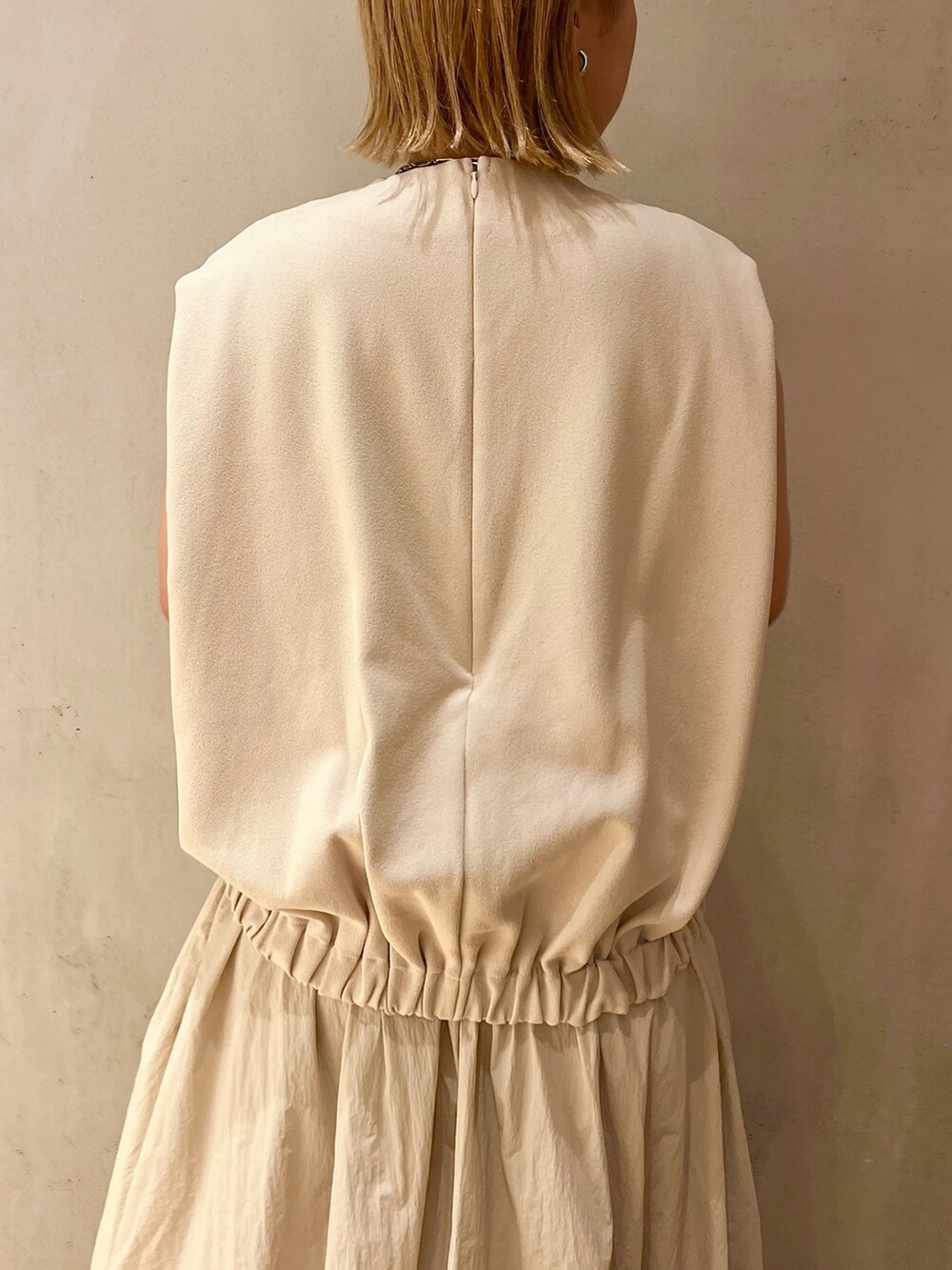 ベージュ系のノーカラージャケット、ベージュ系のワンピース、ブラック系のブーツを着用したレディースの夏コーディネートの7枚目の写真