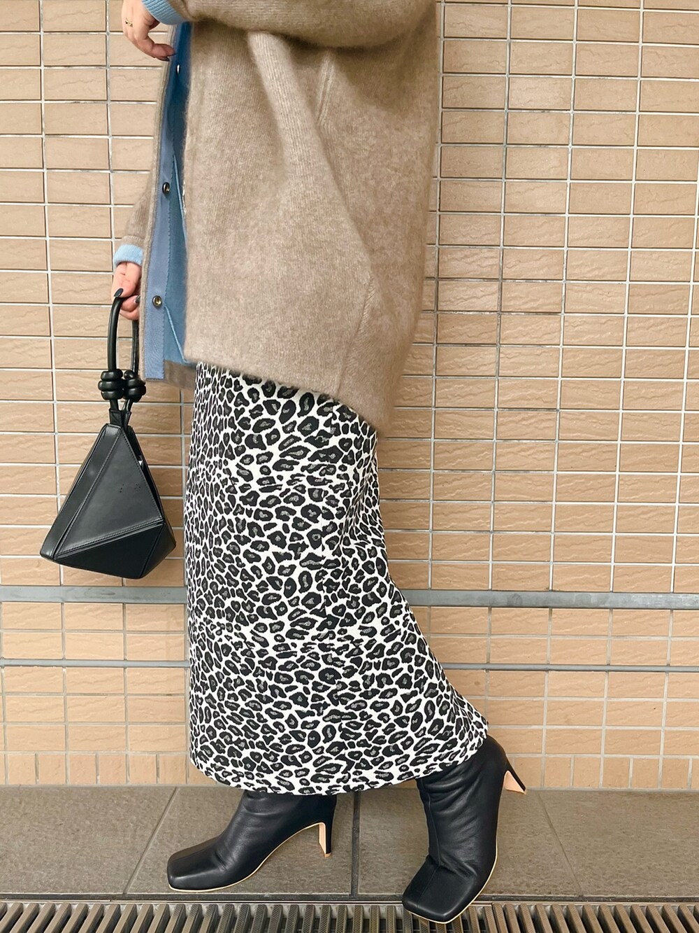 ベージュ系のノーカラージャケット、ブラック系のブーツ、ブラック系のハンドバッグを着用したレディースの夏コーディネートの8枚目の写真