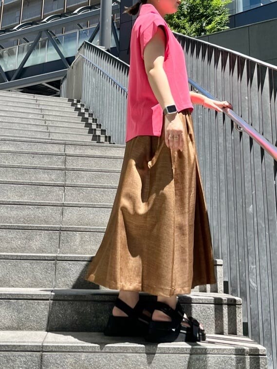 ブラック系のサンダル、ピンク系のTシャツ/カットソー、ブラウン系のスカートを着用したレディースの夏コーディネートの2枚目の写真