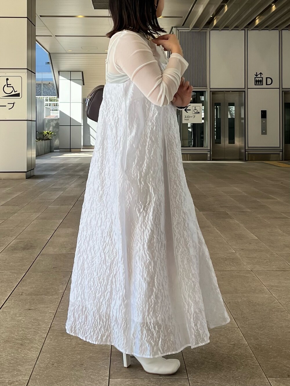 ホワイト系のTシャツ/カットソー、ホワイト系のワンピース、ホワイト系のブーツを着用したレディースの冬コーディネートの5枚目の写真