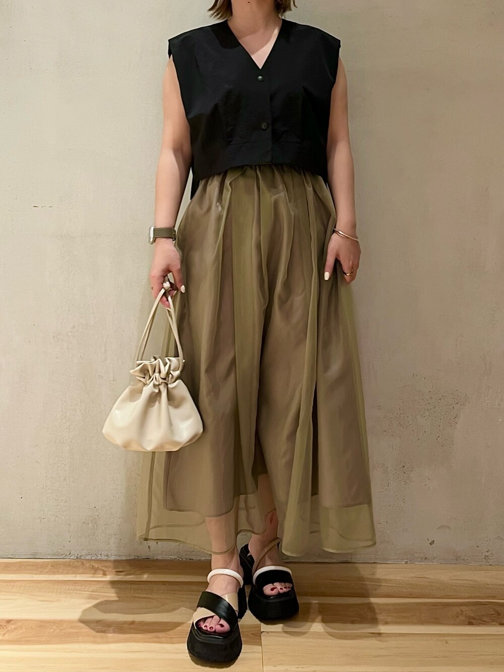 ブラック系のシャツ/ブラウス、ブラウン系のスカート、その他のサンダルを着用したレディースの冬コーディネートの2枚目の写真