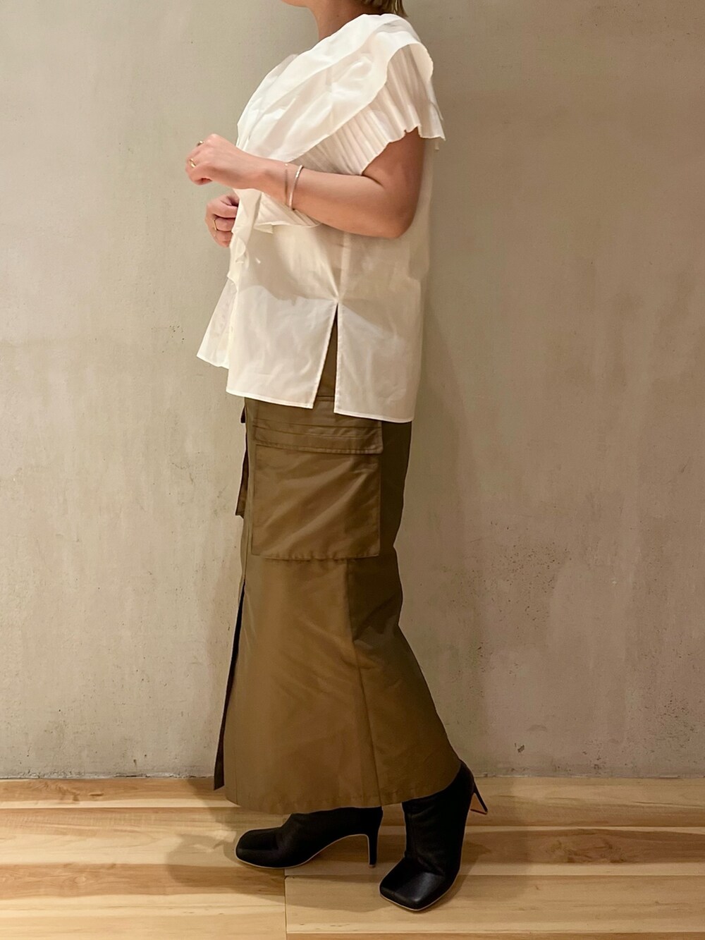 ホワイト系のシャツ/ブラウス、ブラウン系のスカート、ブラック系のブーツを着用したレディースの春コーディネートの2枚目の写真