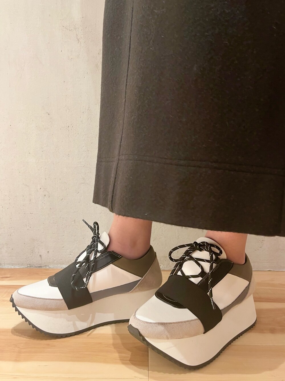 イエロー系のダウンジャケット/コート、グレー系のニット/セーター、ベージュ系のショルダーバッグを着用したレディースの冬コーディネートの10枚目の写真