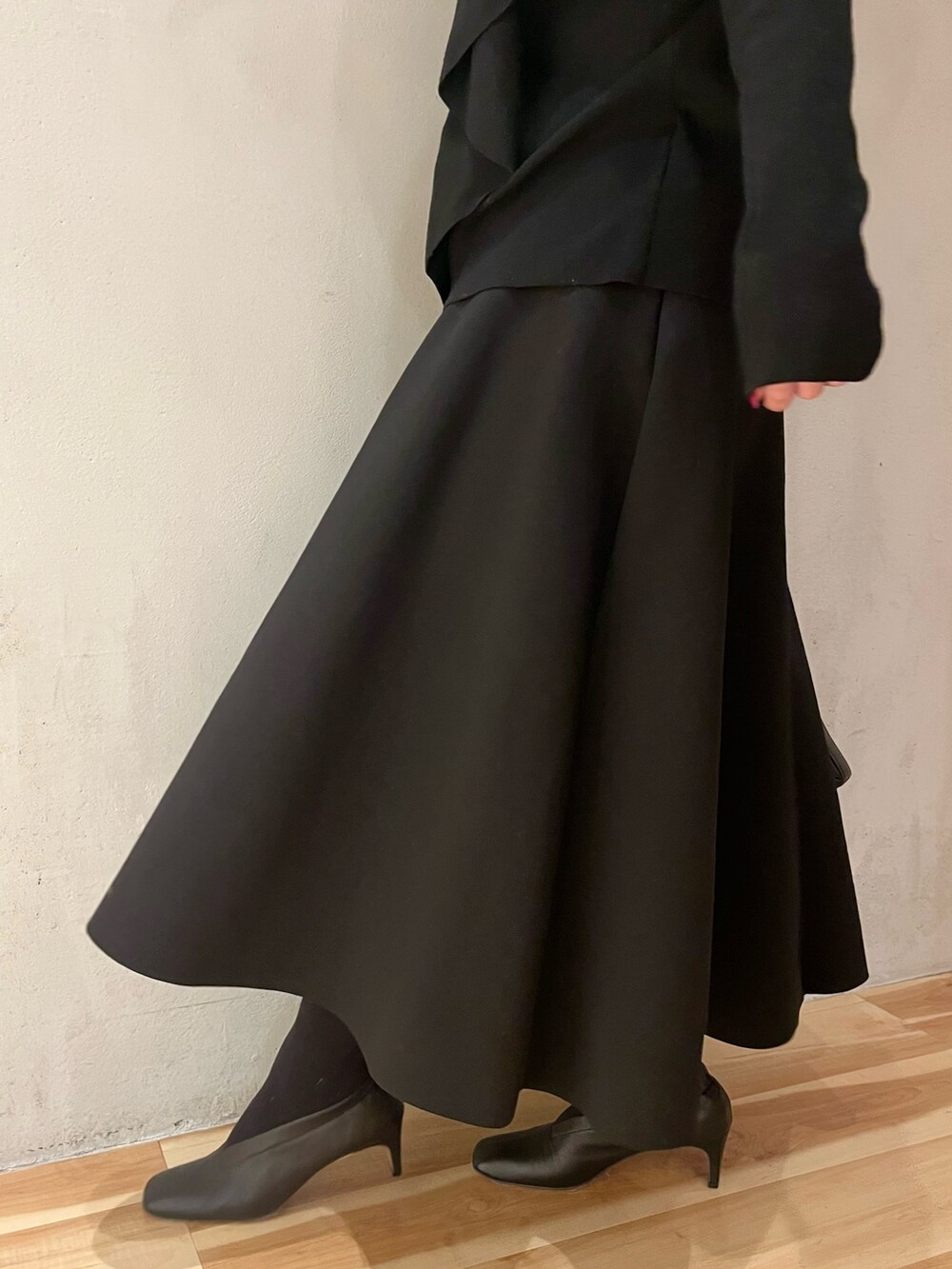 イエロー系のカーディガン/ボレロ、ブラック系のニット/セーター、ブラック系のスカートを着用したレディースの冬コーディネートの9枚目の写真