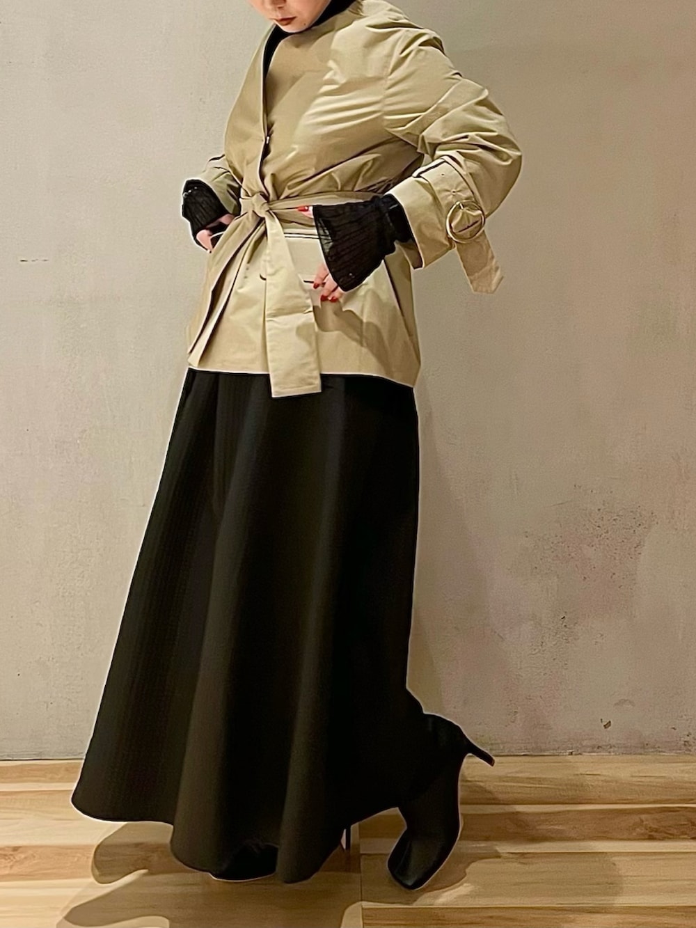 ベージュ系のノーカラージャケット、ブラック系のニット/セーター、ブラック系のスカートを着用したレディースの秋コーディネートの2枚目の写真