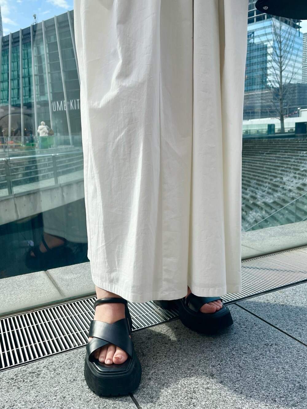 ブラック系のサンダル、ホワイト系のワンピース、ブラック系のハンドバッグを着用したレディースの冬コーディネートの8枚目の写真