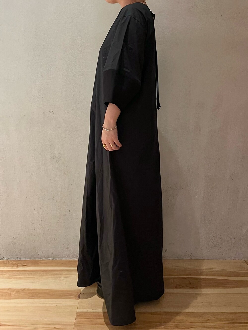 ブラック系のワンピース、ブラック系のブーツを着用したレディースの春コーディネートの3枚目の写真