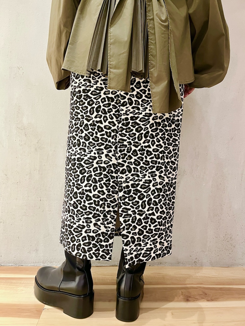 グリーン系のシャツ/ブラウス、ホワイト系のスカート、ブラック系のブーツを着用したレディースの秋コーディネートの8枚目の写真