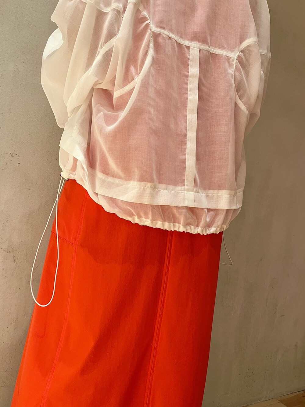 ホワイト系のブルゾン、レッド系のワンピース、ホワイト系のスニーカーを着用したレディースの夏コーディネートの5枚目の写真