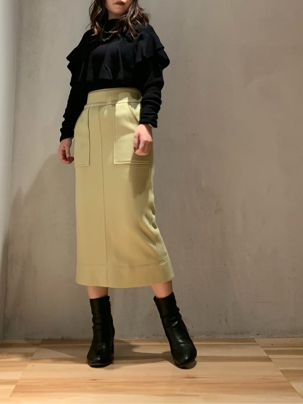 ブラック系のその他アウター、イエロー系のスカート、ブラック系のニット/セーターを着用したレディースの秋コーディネートの3枚目の写真