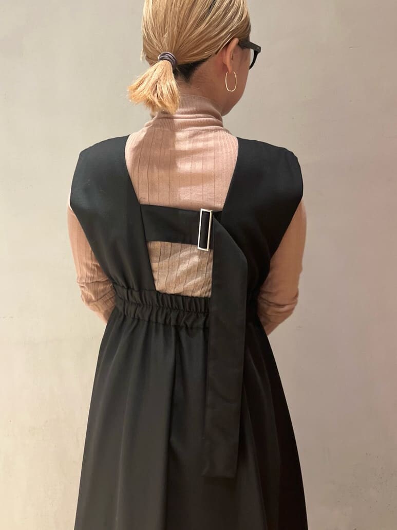 ブラック系のジャンパースカート、ブラウン系のニット/セーター、グリーン系のチェスターコートを着用したレディースの秋コーディネートの10枚目の写真