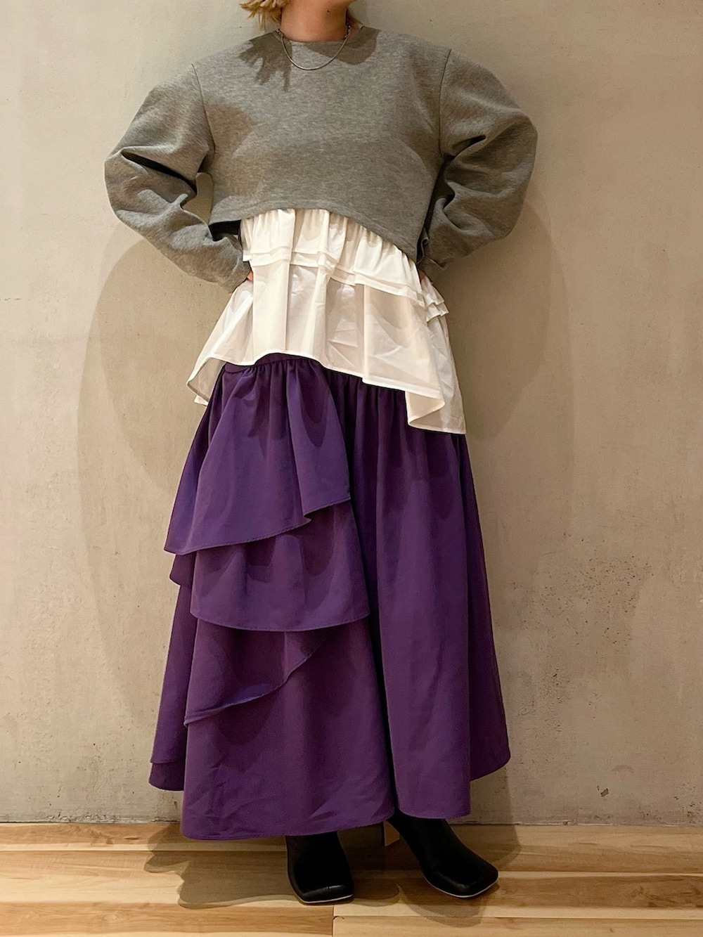 グレー系のTシャツ/カットソー、パープル系のスカート、ブラック系のブーツを着用したレディースの夏コーディネートの4枚目の写真