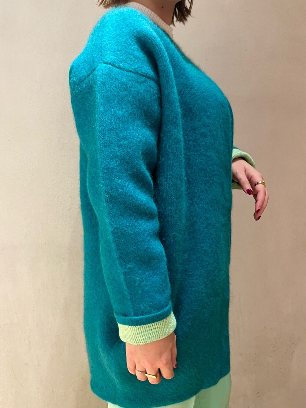 グリーン系のカーディガン/ボレロ、ホワイト系のニット/セーター、グリーン系のその他パンツを着用したレディースの冬コーディネートの6枚目の写真