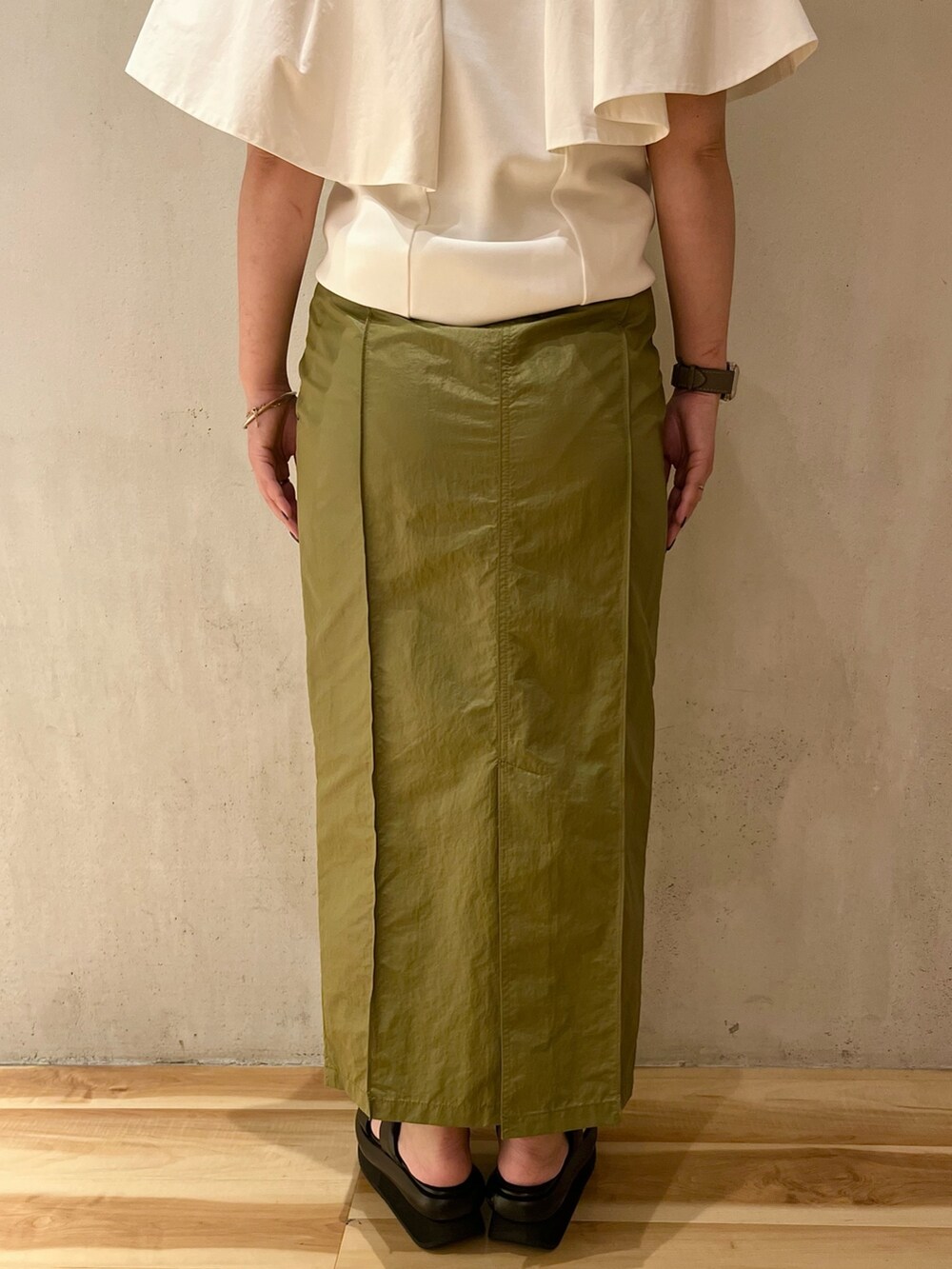 ホワイト系のTシャツ/カットソー、グリーン系のスカート、ブラック系のサンダルを着用したレディースの春コーディネートの8枚目の写真