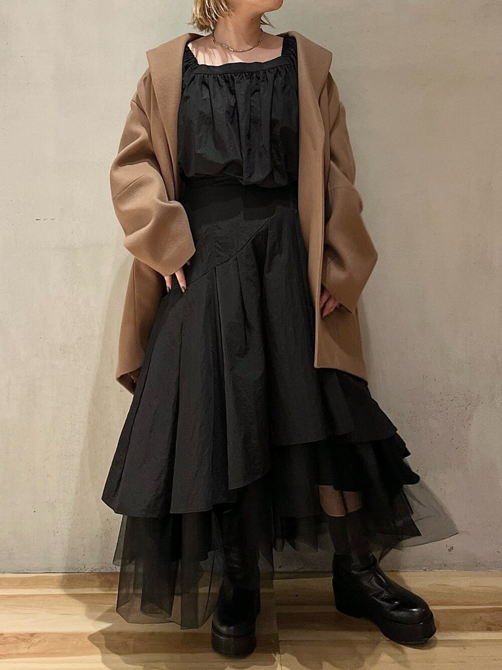 ブラック系のシャツ/ブラウス、ブラック系のスカート、ブラック系のブーツを着用したレディースの秋コーディネートの5枚目の写真