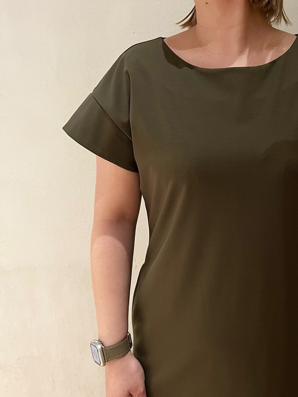 ホワイト系のサンダル、ホワイト系のブルゾン、グリーン系のワンピースを着用したレディースの冬コーディネートの7枚目の写真