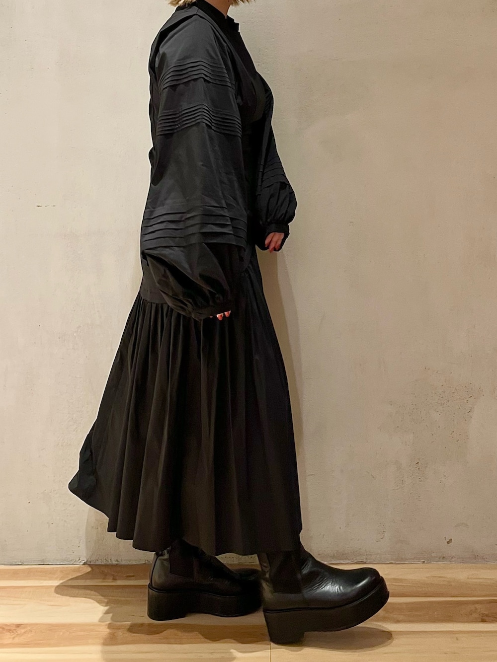 グリーン系のノーカラージャケット、ブラック系のワンピース、ブラック系のブーツを着用したレディースの秋コーディネートの7枚目の写真