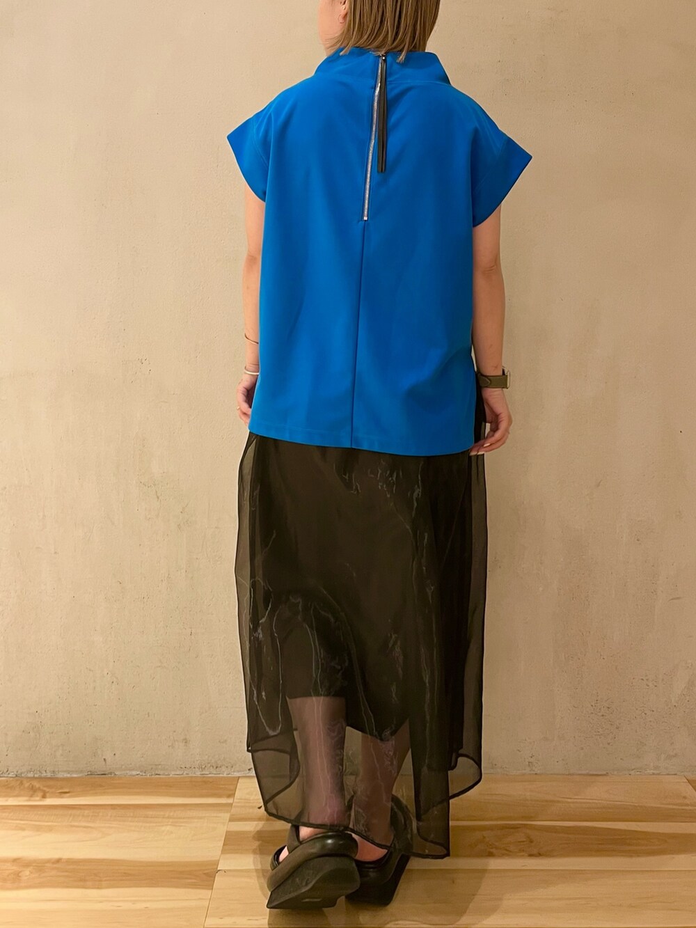 ブルー系のTシャツ/カットソー、ブラック系のスカート、ブラック系のサンダルを着用したレディースの冬コーディネートの3枚目の写真