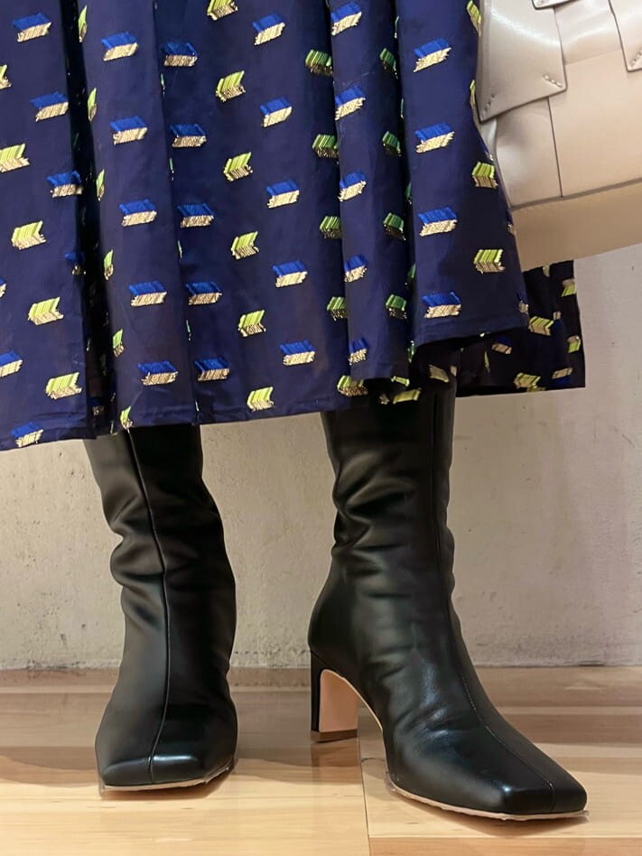 ブラック系のブーツ、ブルー系のスカート、ブルー系のニット/セーターを着用したレディースの秋コーディネートの8枚目の写真