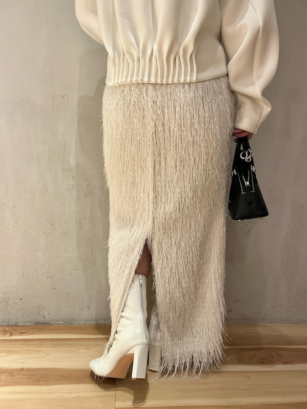 ホワイト系のTシャツ/カットソー、ホワイト系のスカート、ホワイト系のブーツを着用したレディースの春コーディネートの8枚目の写真