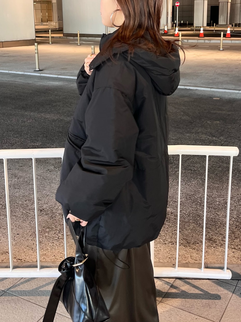 ブラック系のダウンジャケット/コート、ブラウン系のニット/セーター、ブラウン系のスカートを着用したレディースの冬コーディネートの5枚目の写真