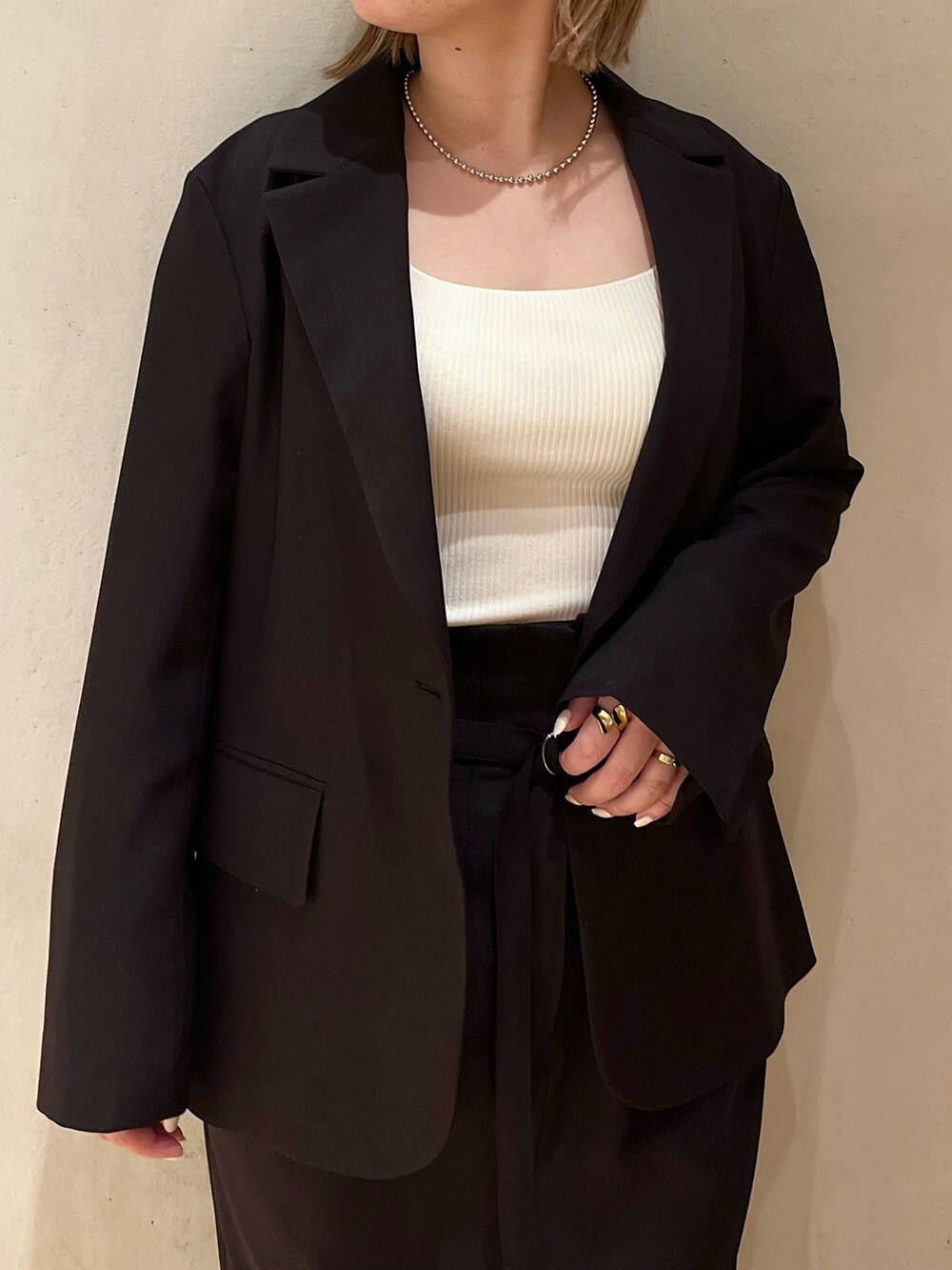 ブラック系のテーラードジャケット、ブラック系のスカート、ブラック系のスニーカーを着用したレディースの冬コーディネートの5枚目の写真