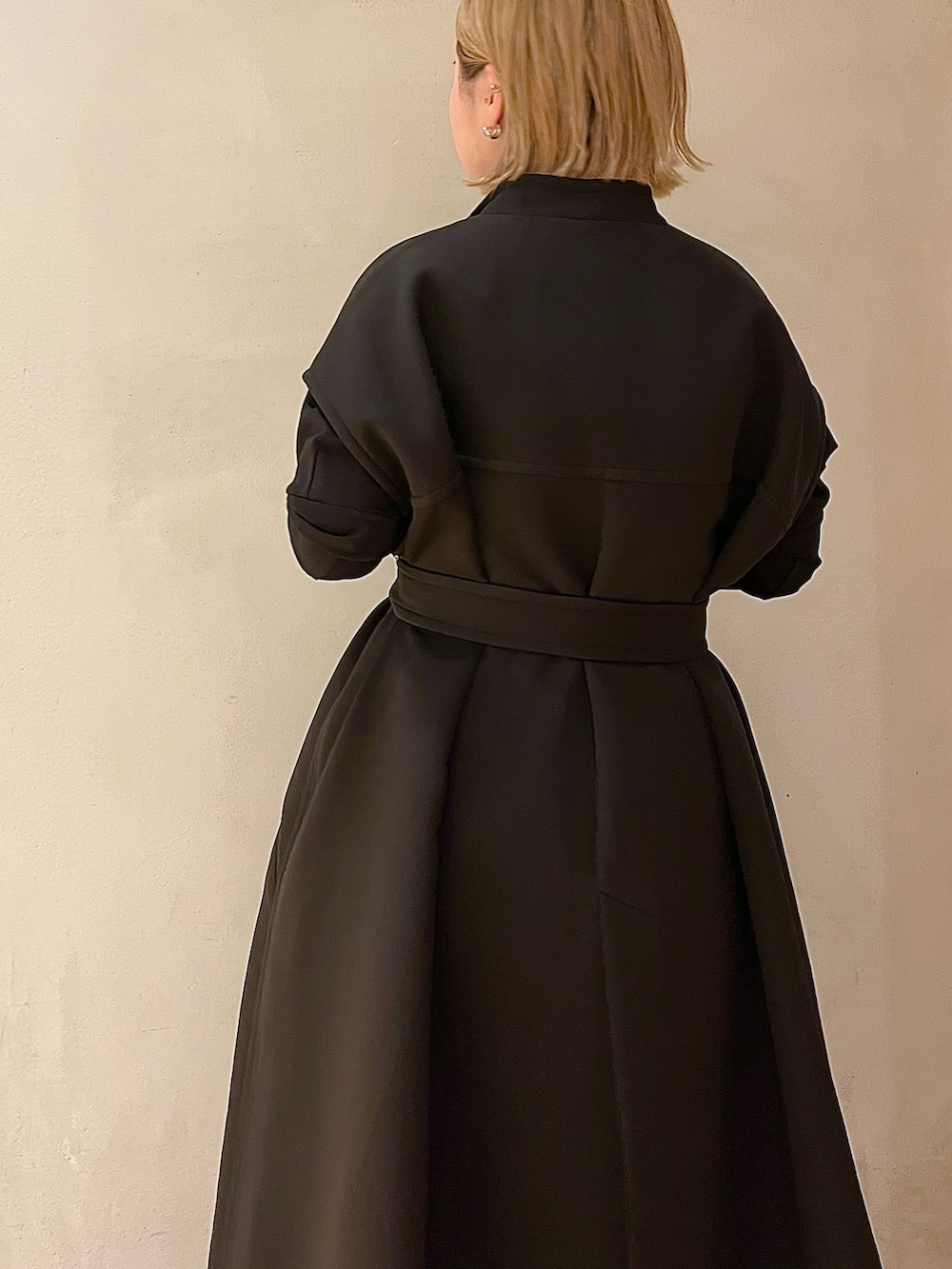 ブラック系のTシャツ/カットソー、ホワイト系のスカート、ブラック系のブーツを着用したレディースの春コーディネートの6枚目の写真