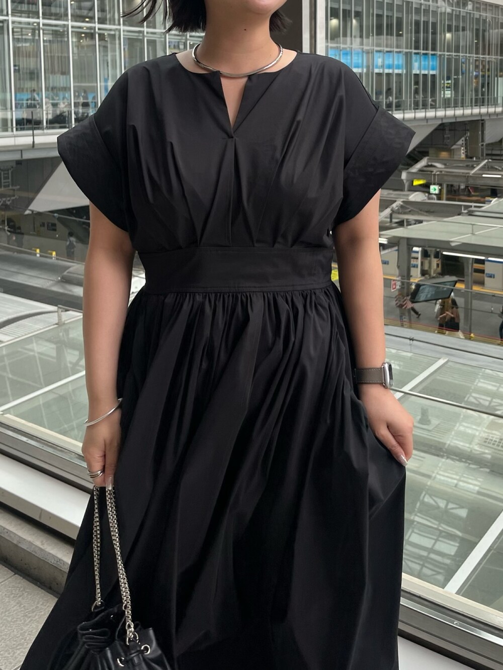 ブラック系のワンピース、ブラック系のショルダーバッグ、その他のサンダルを着用したレディースの春コーディネートの4枚目の写真