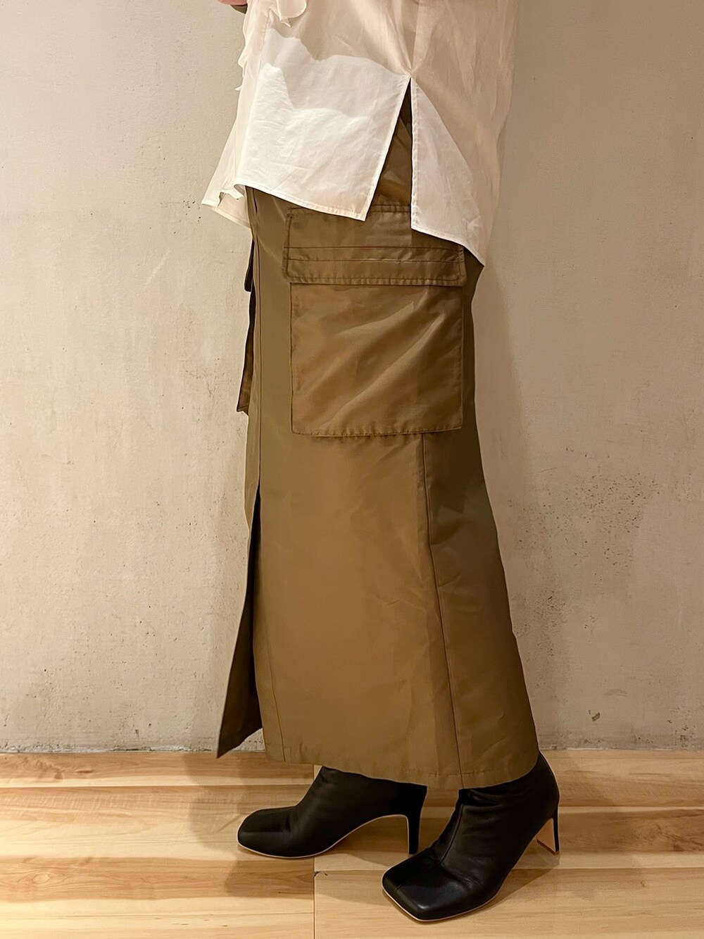 ホワイト系のシャツ/ブラウス、ブラウン系のスカート、ブラック系のブーツを着用したレディースの春コーディネートの9枚目の写真