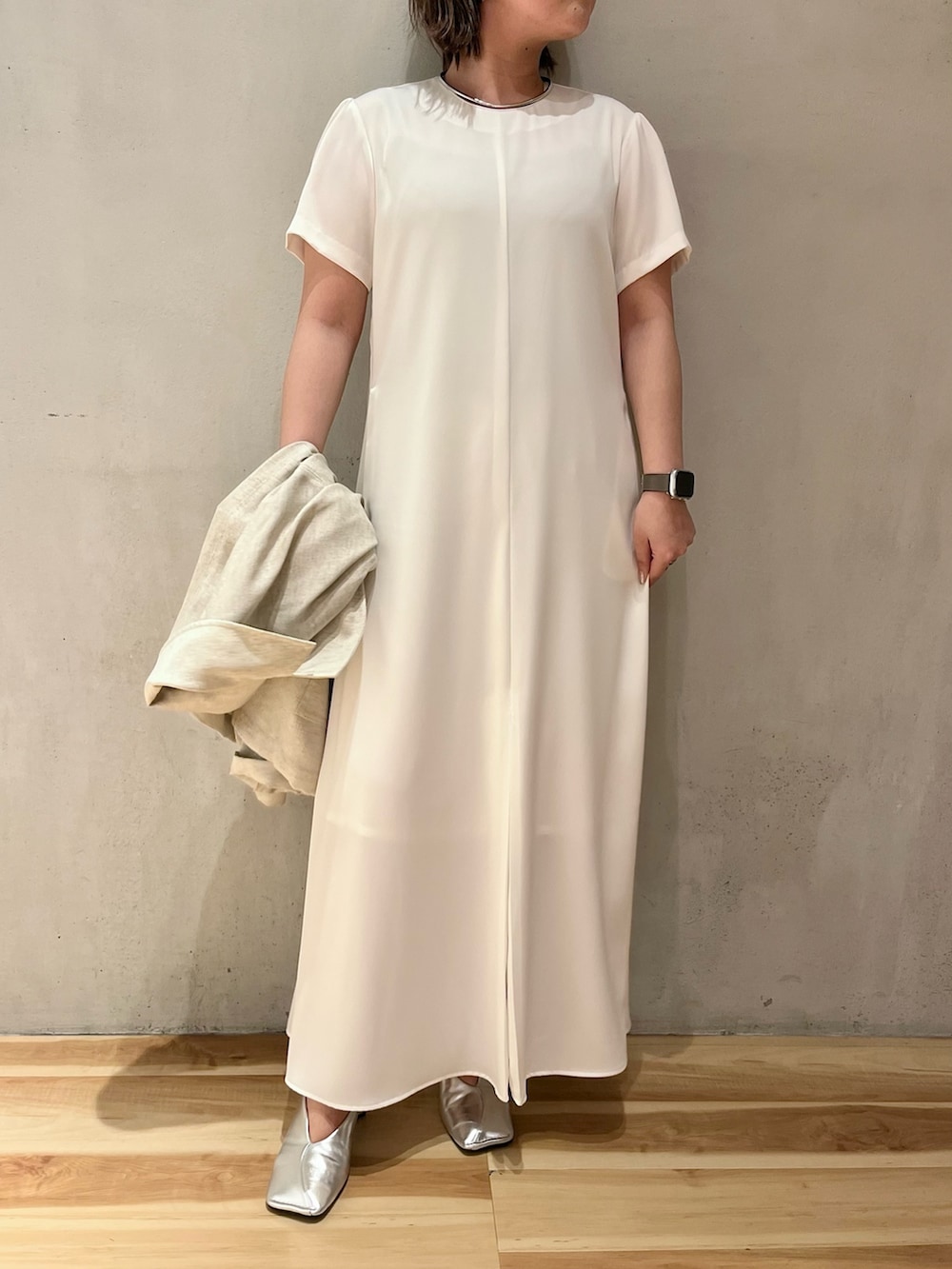 ベージュ系のテーラードジャケット、ホワイト系のワンピース、シルバー系のショルダーバッグを着用したレディースの春コーディネートの7枚目の写真